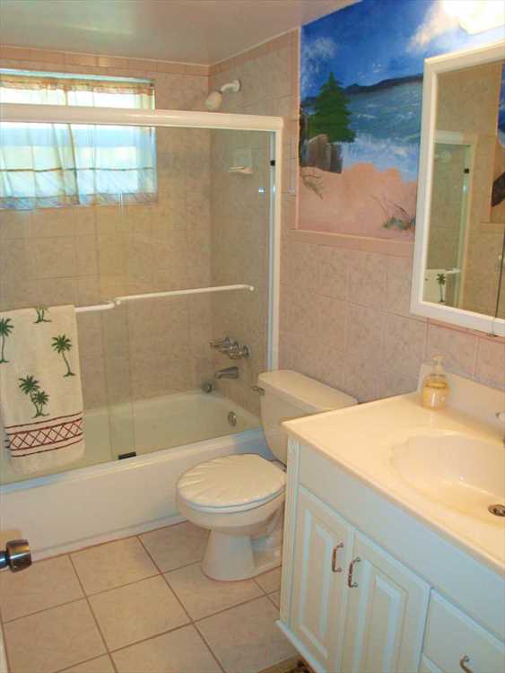 Full second bath with beach and ocean mural keeps the Florid