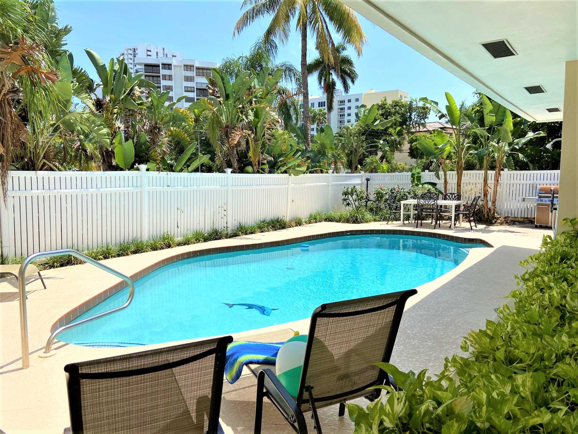 Pool deck is surrounded by a privacy fence.
